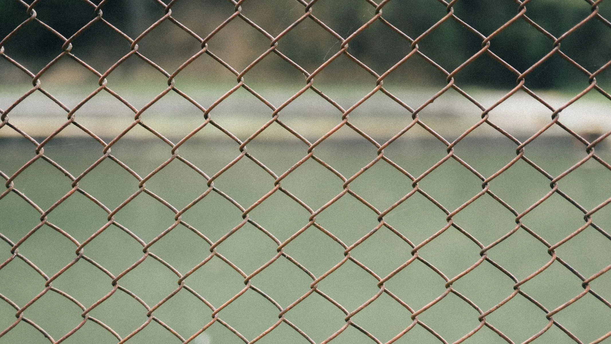 Chain link panels braced on feet along a site boundary